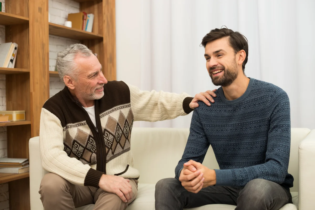 Two individuals seated on a couch in a cozy setting, sharing a moment of connection and support—symbolizing trust, empathy, and open conversation.